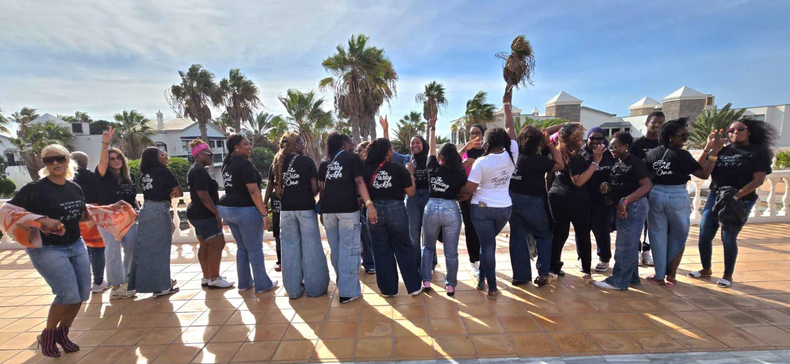 Group celebrating a milestone birthday on a palm-lined terrace
